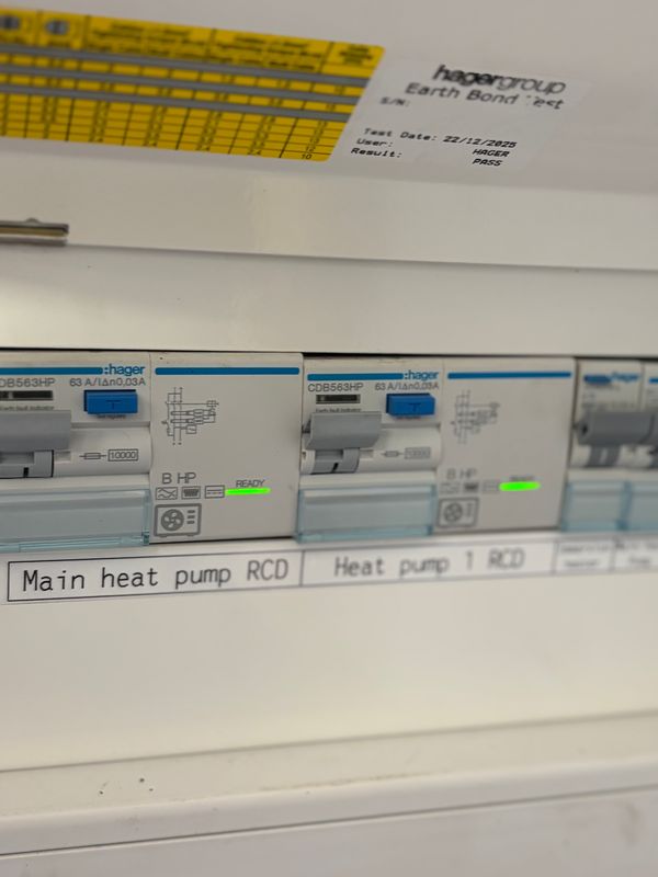 Close-up of labelled Hager heat pump RCDs with their ready indicators lit, installed by AK Electrical